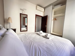 A hotel room with a bed, a mirror, an air conditioning unit, and a wardrobe. - Casa Aligi by FlorenceHospitality (Firenze)