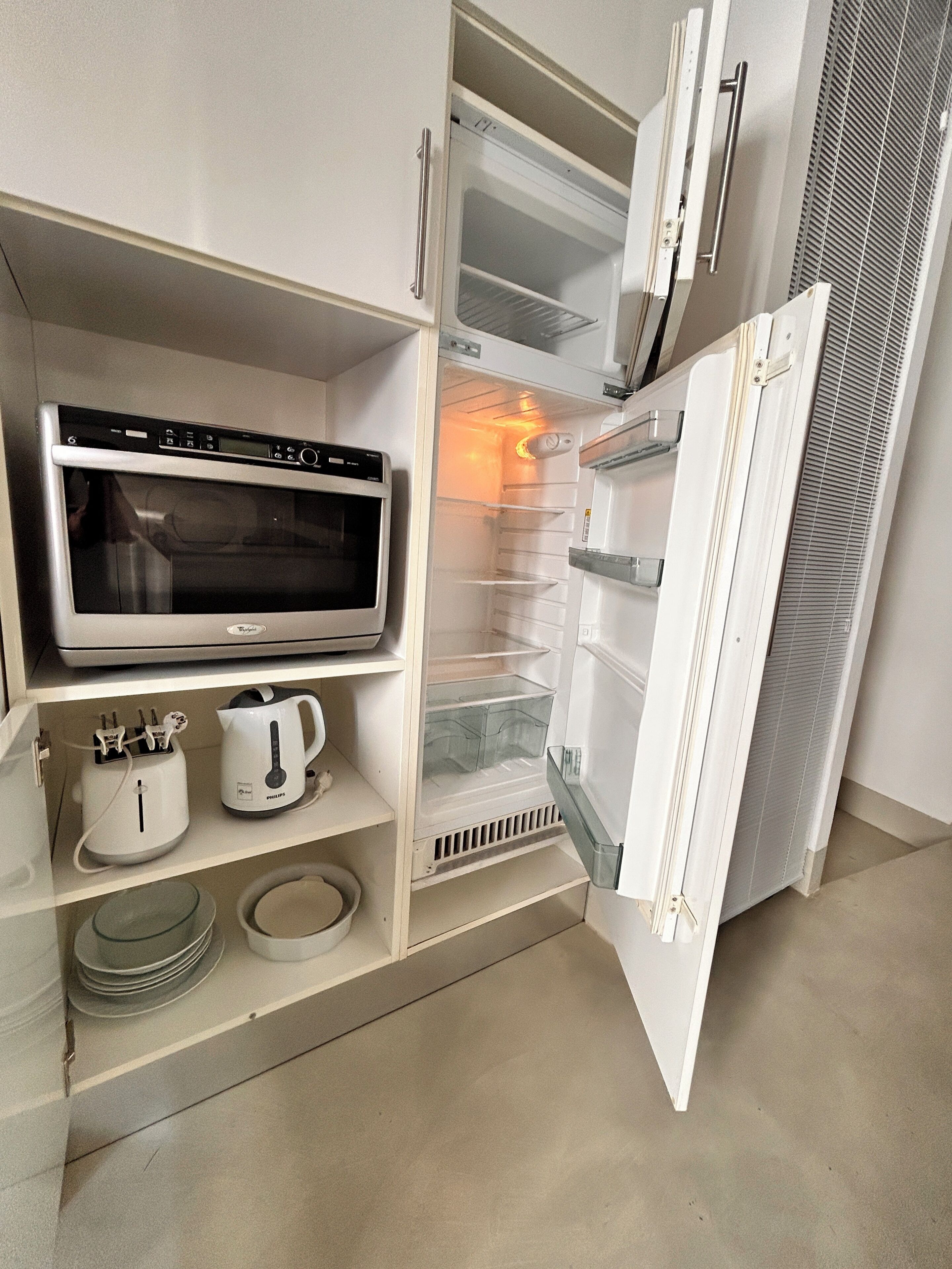 A modern kitchen with a built-in microwave, a coffee maker, and a toaster.