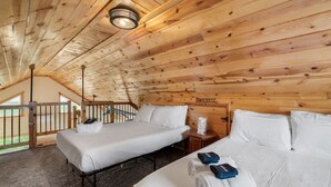 Une cabane en bois avec deux lits, une petite table et une fenêtre.