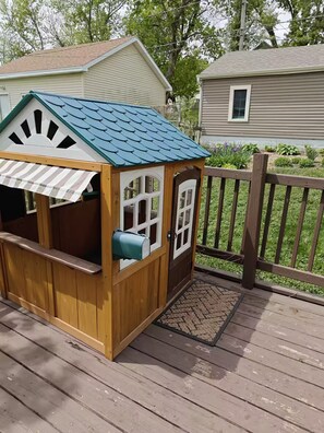A wooden playhouse with a green roof and a mailbox attached to the side. - Cozy 3 Bedroom Home in Omaha (Omaha)
