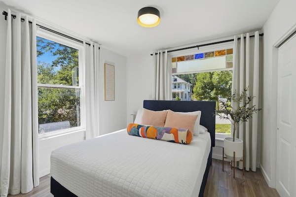 Unwind in a comfortable queen bed with plush, cozy pillows.