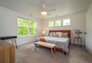 A bedroom with a bed, a bench, a desk, a ceiling fan, and windows. - 3BR Retreat w/ Deck + Fire Pit | Sleeps 8 | Free Tix (Hendersonville)