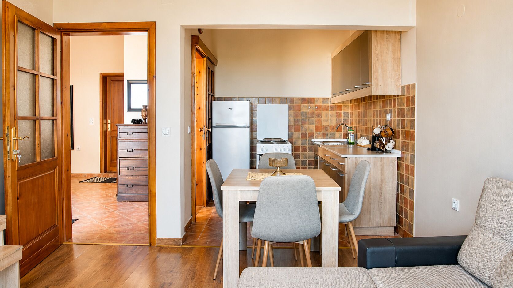 Una cocina compacta con comedor, armarios de madera y salpicadero de azulejos.