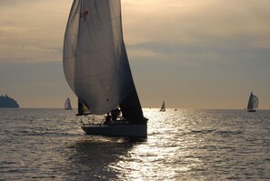 Ein Segelboot auf ruhigem Wasser mit einer entfernten Küstenlinie.