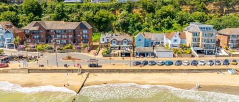 A coastal town with beachfront properties, a sandy beach, and a pier.