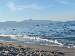A beach with waves, a clear sky, and mountains in the distance. - La Marana house, beach 100m away, air-conditioned, terrace and garden. Sleeps 4/6. (Borgo)