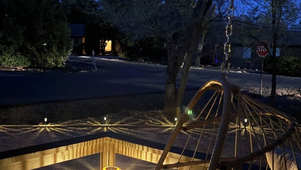 A hammock chair with cushions, a small table, and a lit lantern in an outdoor setting. - 4-bedroom house in Sedona with hot tub, firepit & grill - walk to hiking trails (Sedona)