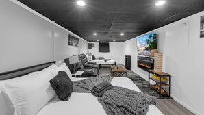 Ein modernes Hotelzimmer mit einem Bett, zwei Sitzbereichen, einem Fernseher und einem Kamin.