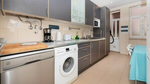 A modern kitchen with Bosch appliances, a washing machine, and a sink.