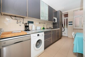 Eine moderne Küche mit Bosch-Geräten, einer Waschmaschine und einem Spülbecken.