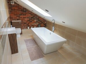 A modern bathroom with a large bathtub, a toilet, and a sink. - Stagwood House (Holmfirth)