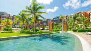 Ein Resort mit Swimmingpool, Palmen und mehrstöckigen Gebäuden.