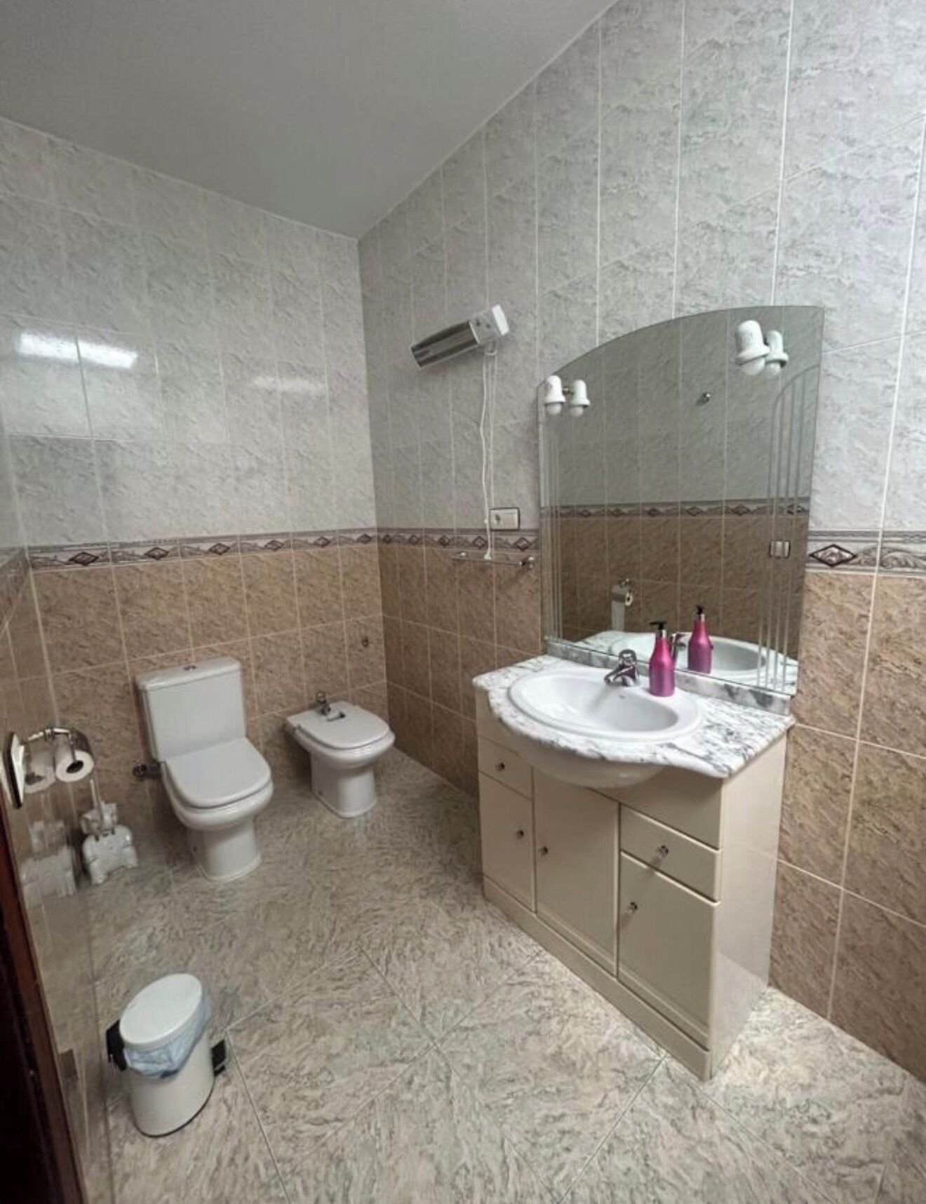 A bathroom with a toilet, bidet, and sink.
