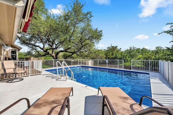 A swimming pool with a deck, lounge chairs, and a tree in the background. - Pop's Place: Private Pool & Lake Access! (Granite Shoals)