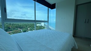 Ein Schlafzimmer mit großem Fenster, einem Bett und einem Kleiderschrank.