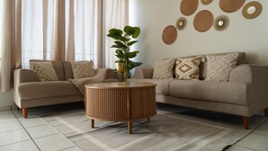 A living room with two sofas, a round coffee table, and a potted plant. - Central Zone Department (La Paz)