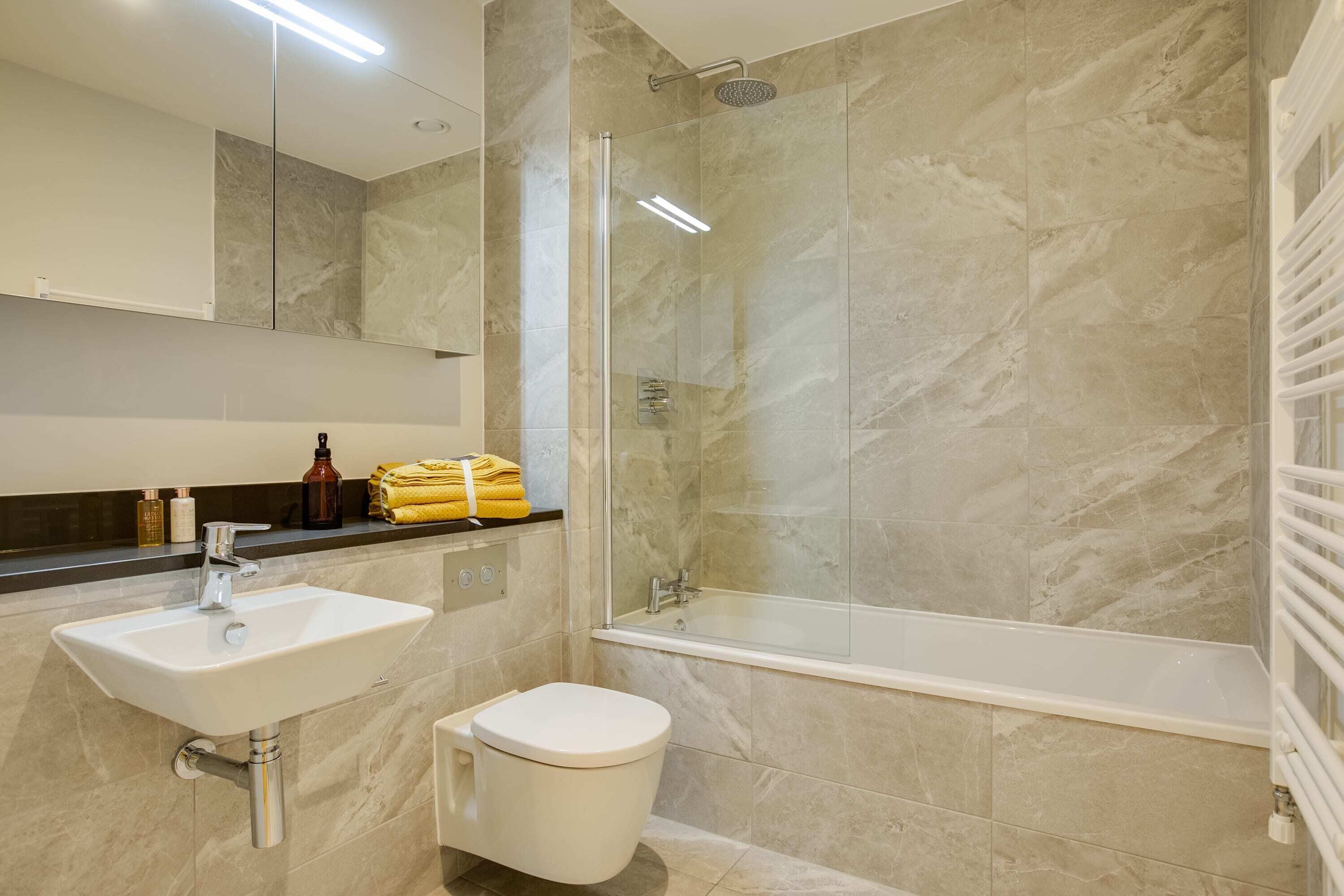 A bathroom with a sink, toilet, and glass-enclosed shower.