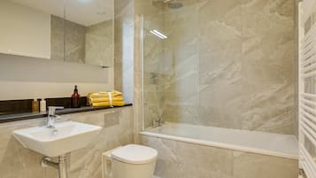 A bathroom with a sink, toilet, and glass-enclosed shower.