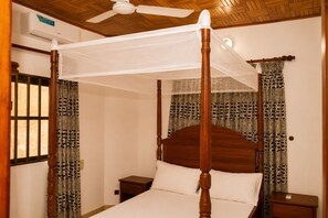 A four-poster bed with a canopy, wooden headboard, and nightstands. - Private Beach House Fidjrosse, 2 Steps to the Ocean (Cotonou)