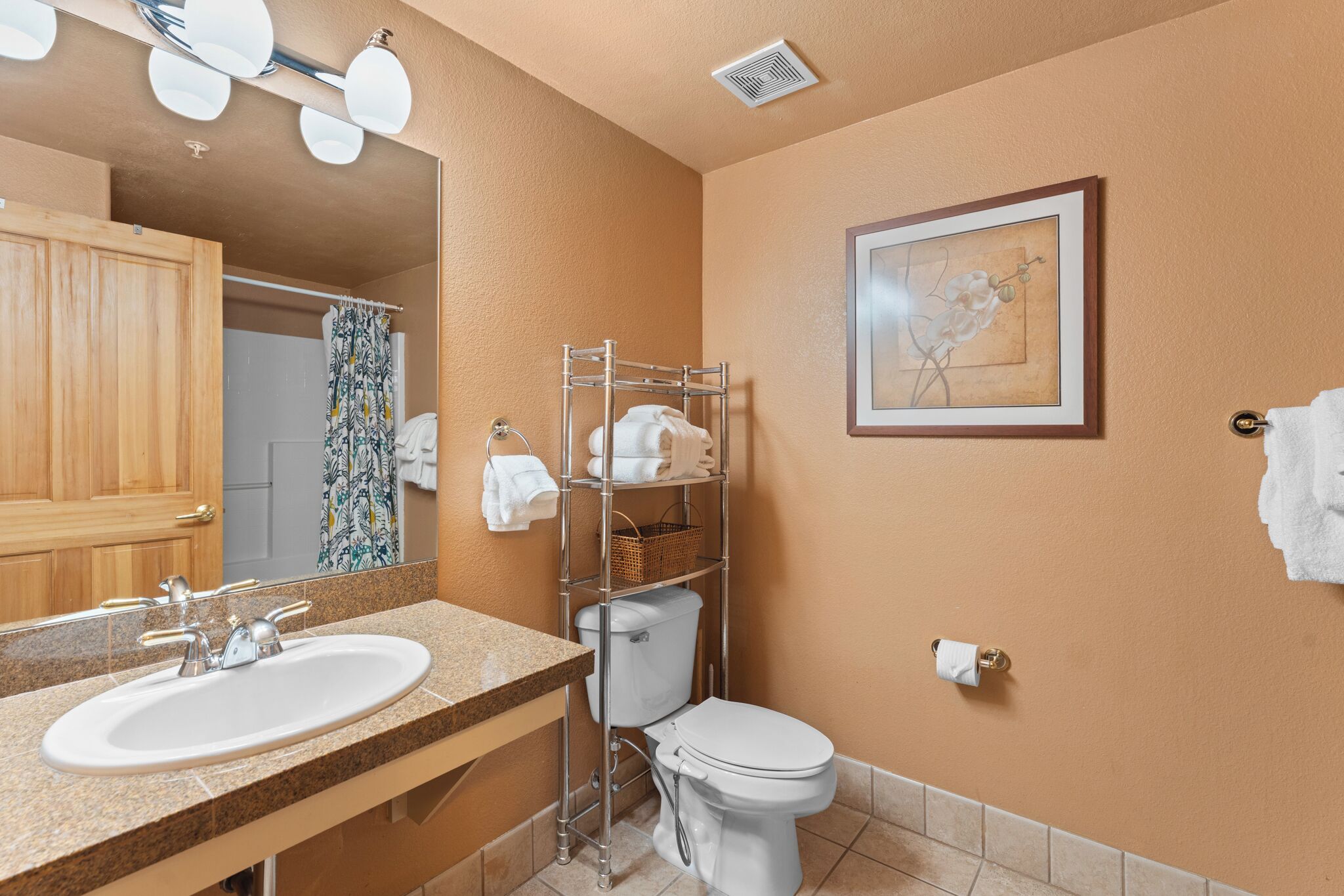 Een badkamer met een wastafel, toilet en handdoekrek.
