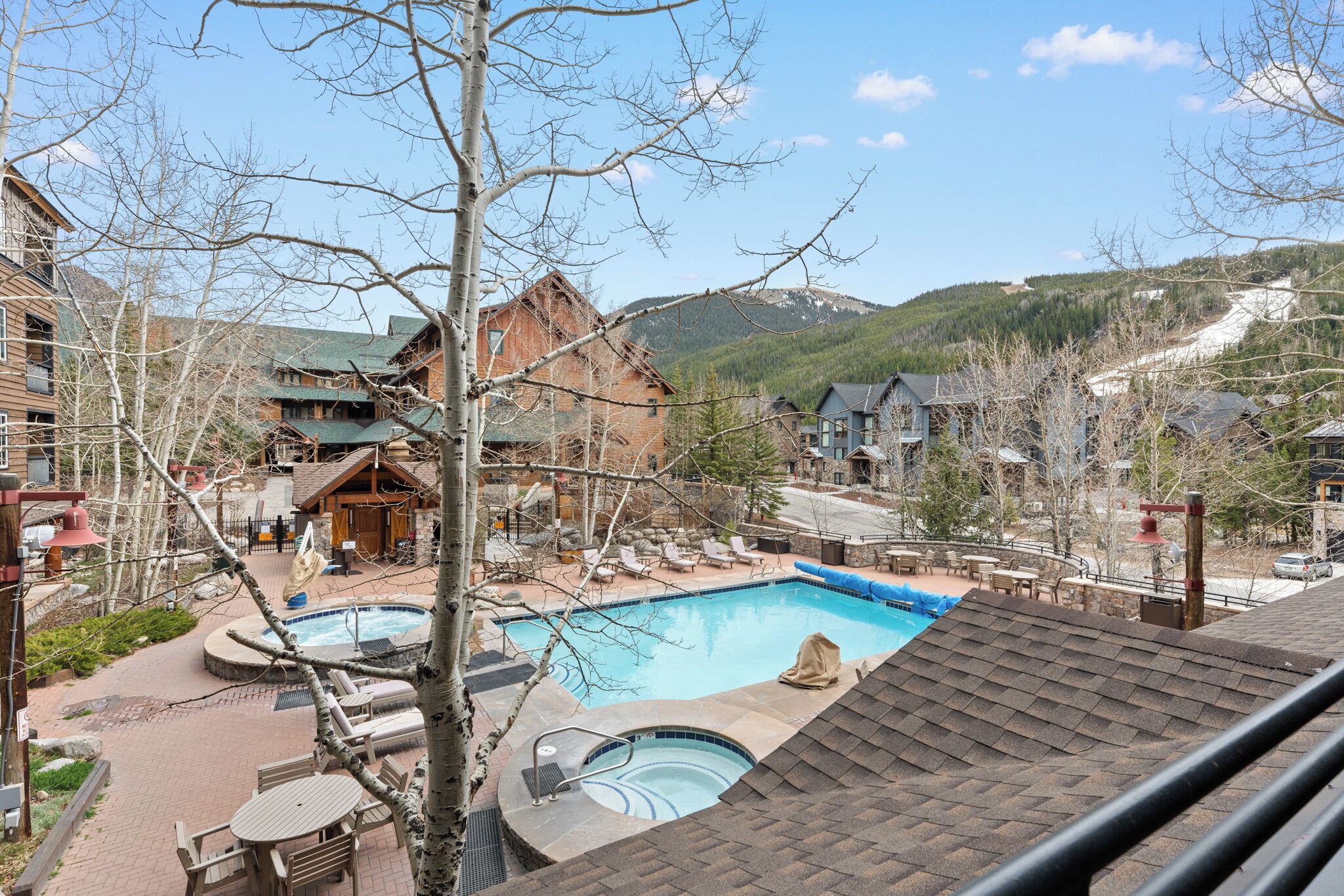 Un complexe hôtelier doté d’une piscine, de chaises longues et offrant une vue sur les montagnes.