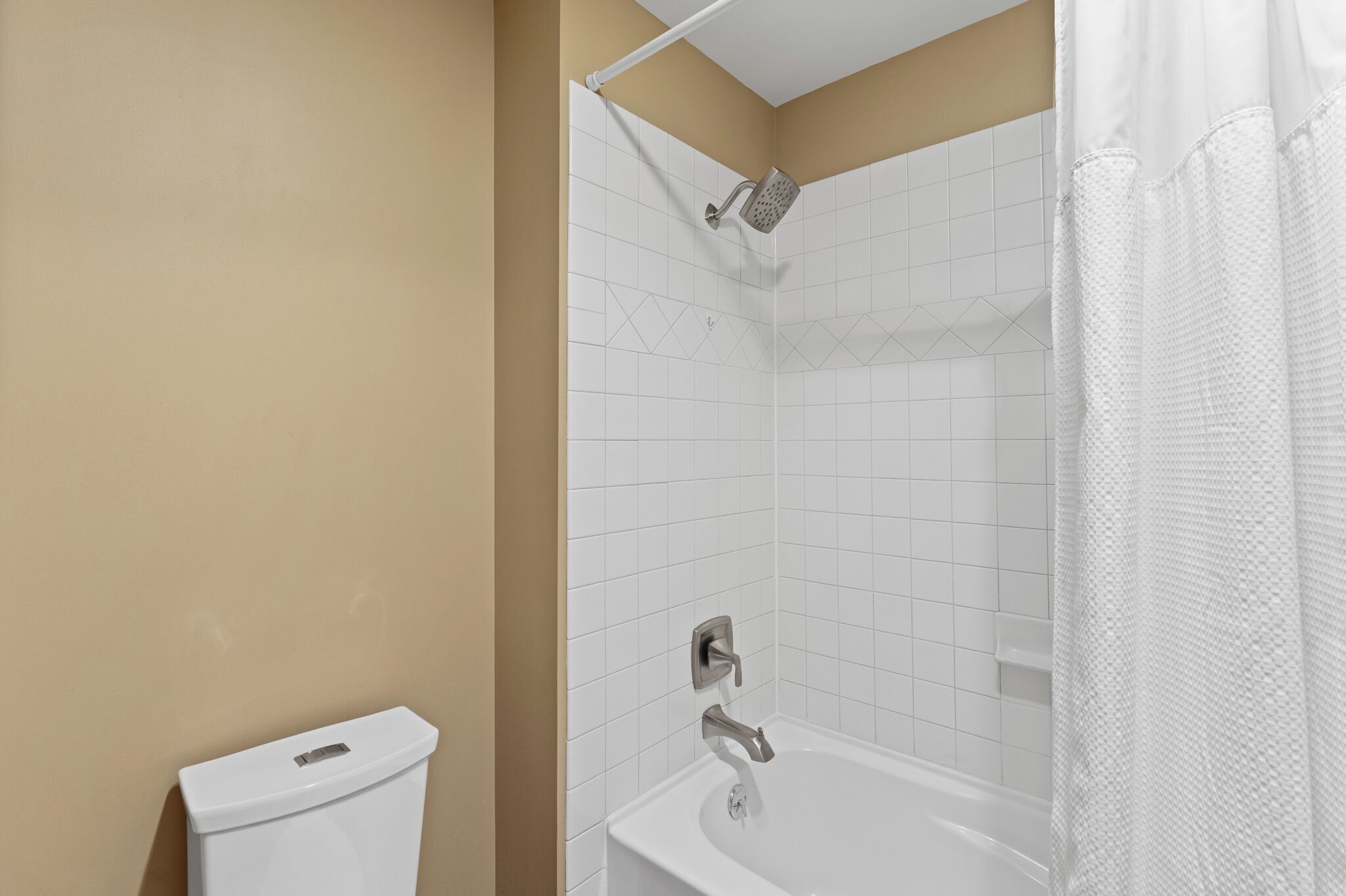 A bathroom with a shower, toilet, and sink.