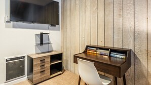 A study room with a wooden desk, a chair, a TV mounted on the wall, and a bookshelf with books. - Sunshine Loft ~ Free Shuttle ~ Pool & Hot Tub (Mammoth Lakes)
