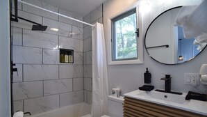 A modern bathroom with a shower, toilet, and sink. - SIngle Room - 1 King Bed -Valley View (Himrod)
