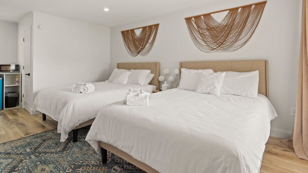 A hotel room with two beds, a minibar, and a patterned rug. - Double Room - 2 Queen Beds - Partial Lake View (Himrod)