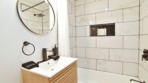 A modern bathroom with a sink, mirror, and shower. - Double Room - 2 Queen Beds - Pool View (Himrod)