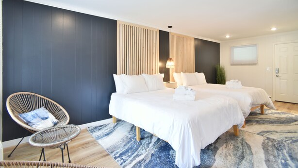 A modern hotel room with a large bed, two bedside tables, a chair, and a large window. - Double Room - 2 Queen Beds - Pool View (Himrod)