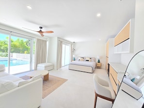 A modern bedroom with a bed, bedside tables, a ceiling fan, and a view of a swimming pool. - Luxe Siesta Key Home Saltwater Pool Cabana - Sleeps 10 Near Beach Casa Tropicana (Siesta Key)