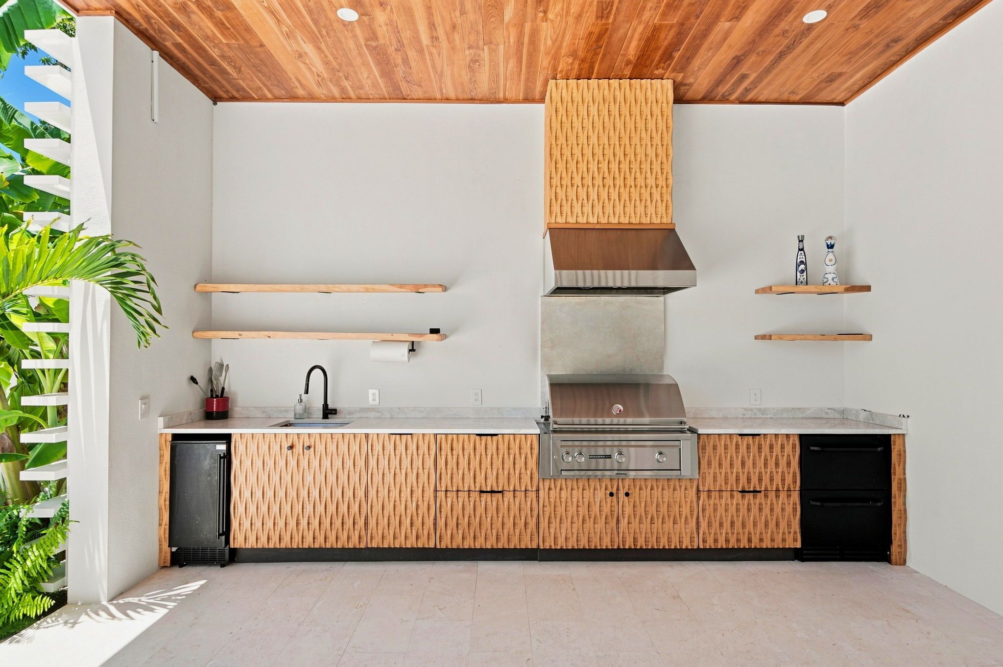 A modern kitchen with a built-in stove, wooden cabinets, and a wooden ceiling.