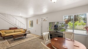 Un salon avec un canapé, une table à manger et un escalier.