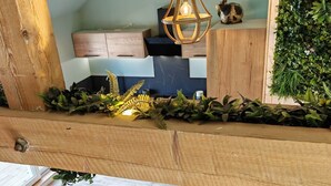 Un coin repas avec une table ronde en bois, quatre chaises et un luminaire suspendu.