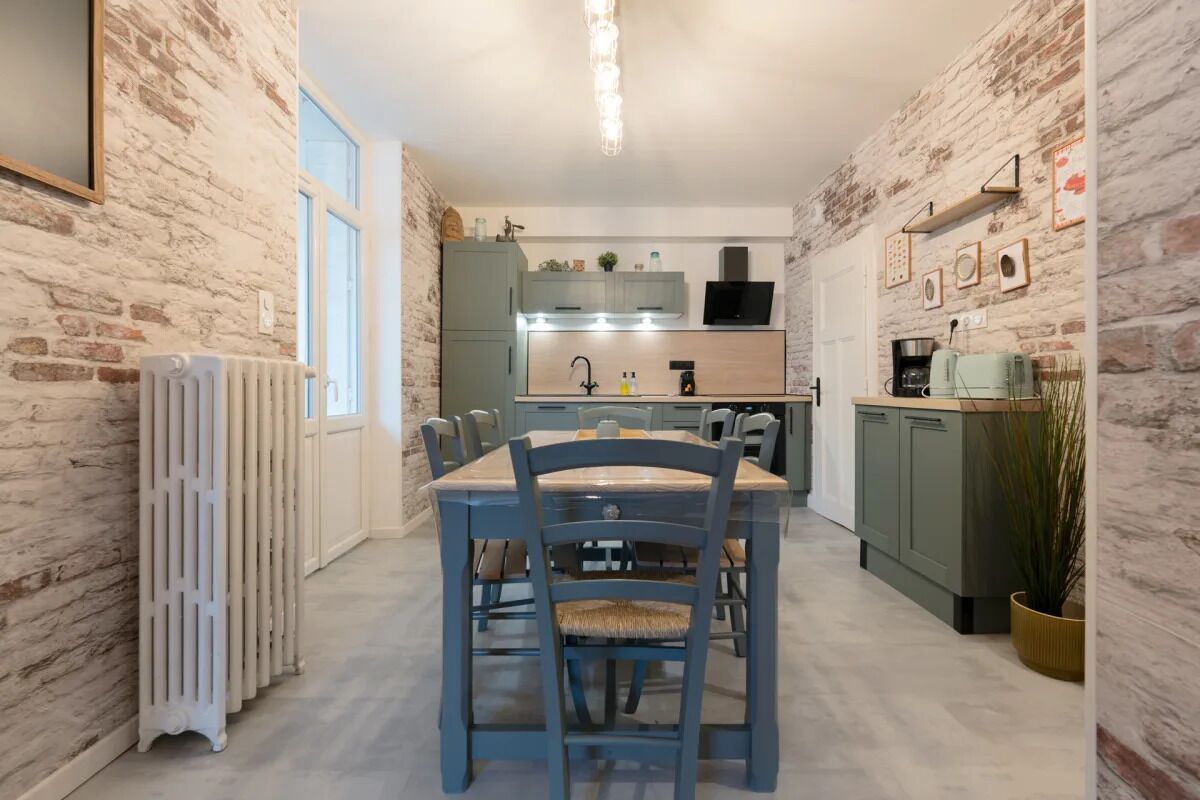 Une cuisine avec une table et des chaises, un radiateur et une plante en pot.
