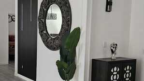 A modern interior with a wooden floor, a large mirror, a potted plant, and a dark wooden cabinet. - beautifly remodel home with spectacular mountain views 6 miles from the mall (Sierra Vista)