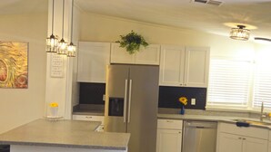 A modern kitchen with a central island, stainless steel appliances, and pendant lighting. - beautifly remodel home with spectacular mountain views 6 miles from the mall (Sierra Vista)