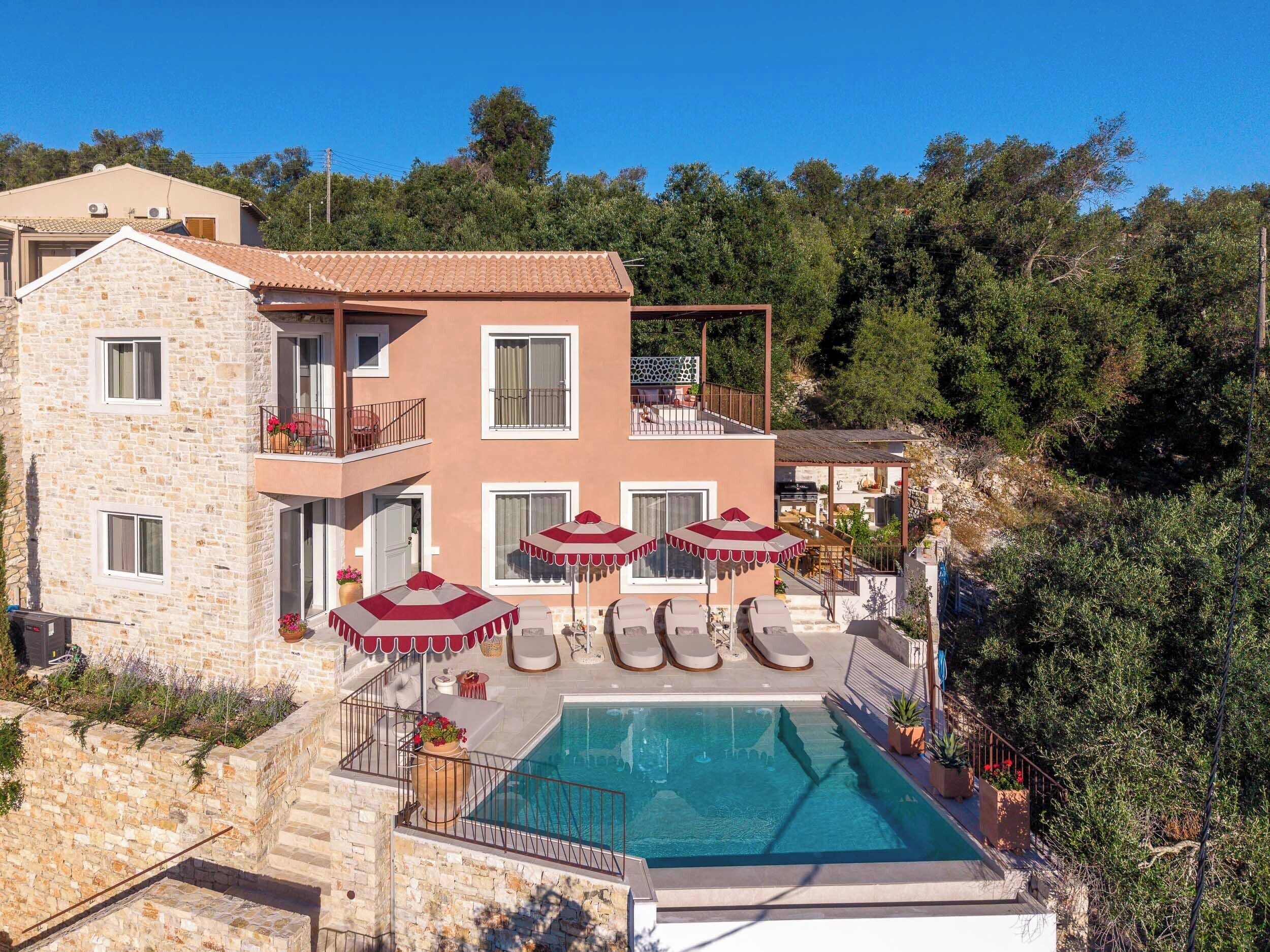 Ein zweigeschossiges Gebäude mit Swimmingpool, Außenbereich zum Sitzen und einem Balkon.