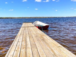 A wooden dock extending into calm water with a small boat tied to it. - 4 Star Holiday Home in Vaxjo (Växjö)