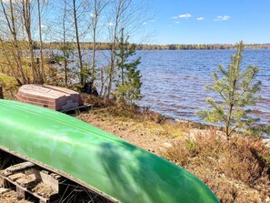 A green canoe on a dock, a covered object, and a small tree by a calm lake. - 4 Star Holiday Home in Vaxjo (Växjö)