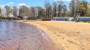 A beach with a pavilion, picnic tables, and a fenced area with benches. - 4 Star Holiday Home in Vaxjo (Växjö)