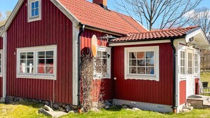 A red wooden house with a sloped roof, a chimney, and a small porch. - 4 Star Holiday Home in Vaxjo (Växjö)