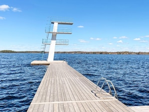 A wooden dock leading to a diving platform with railings, extending into a body of water with a clear sky. - 4 Star Holiday Home in Vaxjo (Växjö)