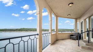 Ein überdachter Balkon mit Blick auf Wasser und Grün.