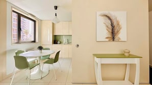 Uma cozinha moderna com área de refeições, janela com vista e uma obra de arte decorativa com penas.