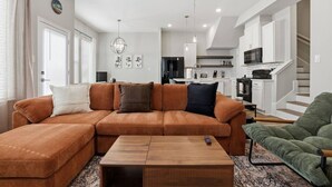 Una sala de estar con un sofá modular, una mesa de centro y un sillón verde.