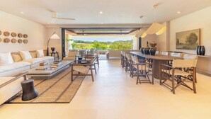Uma sala de estar espaçosa com sofá, mesa de centro e mesa de jantar com cadeiras.