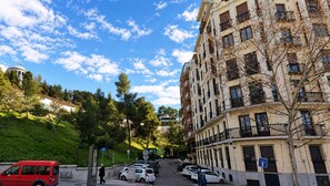 A multi-story residential building with balconies, parked cars, and a pedestrian pathway. - Retiro XII Exclusive Stay (Madrid)