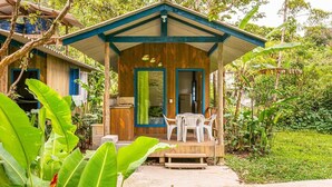 Une cabane en bois avec une véranda, une table et des chaises.
